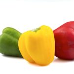 Image of three different coloured peppers. Red, green and yellow